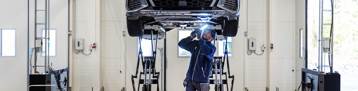 Mekaniker utför orginalservice på en upphöjd bil