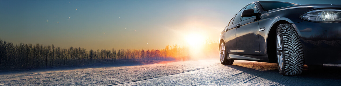 Bil med dubbdäck på snöig väg – Euromaster